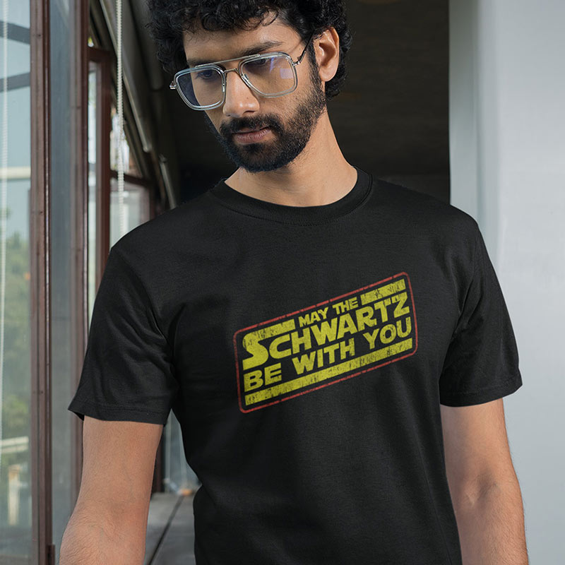 Man modeling movie lover gifts by Dodo Tees. This nerd t shirt reads May The Schwartz Be With You.