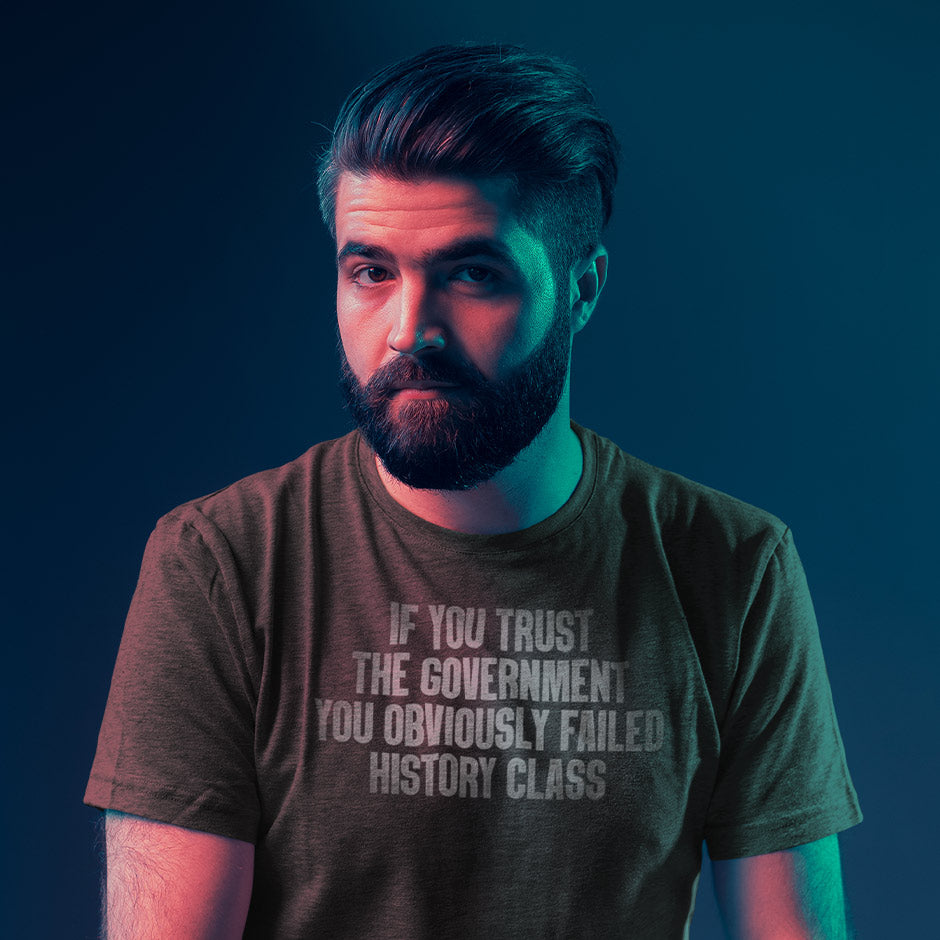 man looking at camera wearing patriotic shirt with if you trust the government you obviously failed history class typography