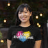 smiling woman outside wearing pride shirt with i love everyone colorful painted graphic