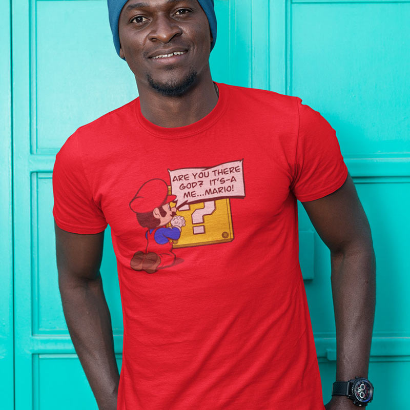 Man wearing a red video game shirt where Mario is on his knees asking Are you there god it's a me Mario.