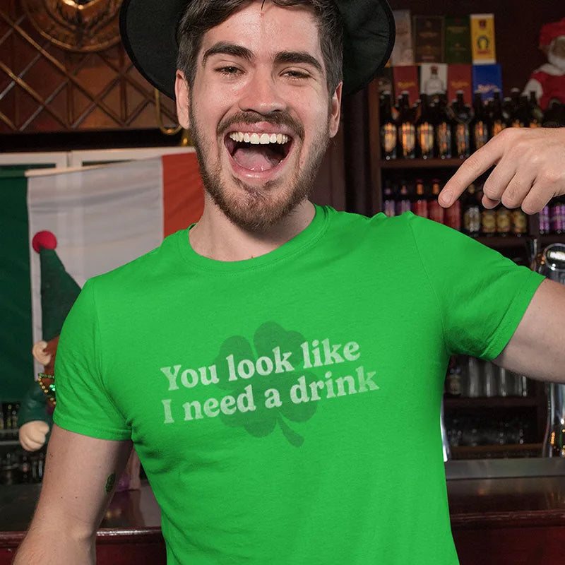 smiling man wearing st pattys day shirt with you look like i need a drink text