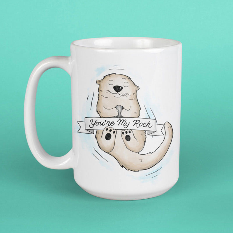 dodo tees animal mug with cartoon drawing of otter holding onto rock