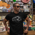 stylish man in record store wearing automobile t shirt with xj splatter graphic by dodo tees