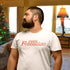 man in iconic living room wearing christmas tee with oh fudge vintage text