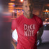  man outside in the city wearing comical t shirt with dick at nite vintage style logo printed on the front of his shirt