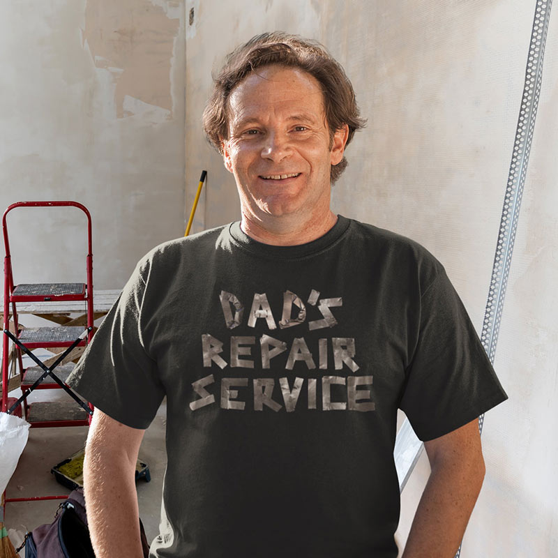 man doing drywall work wearing dad shirt with dads repair service written in duct tape 