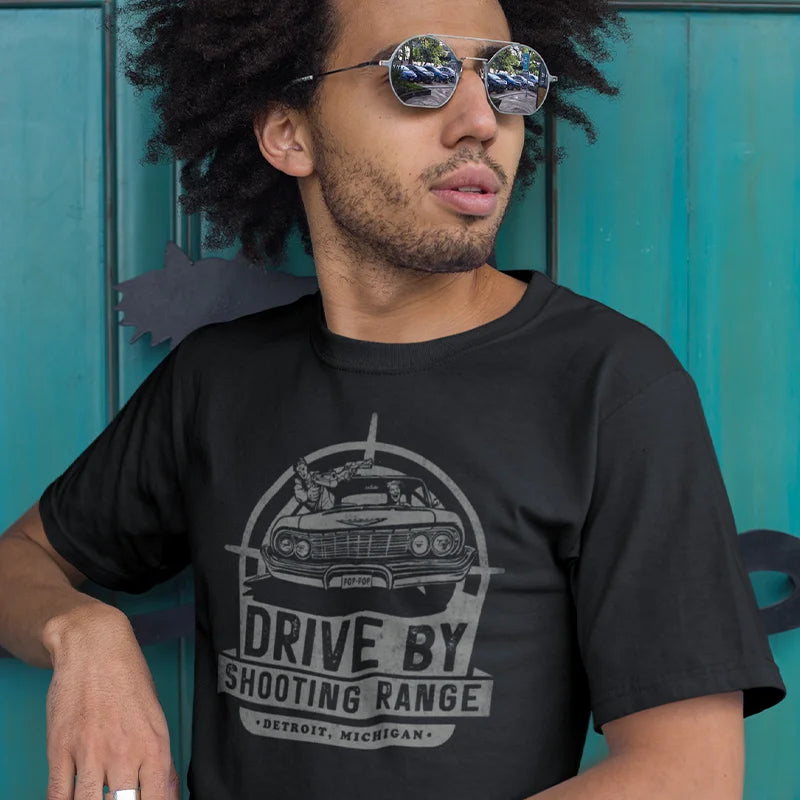 stylish man wearing dark humor graphic tee with drive by shooting range logo in black