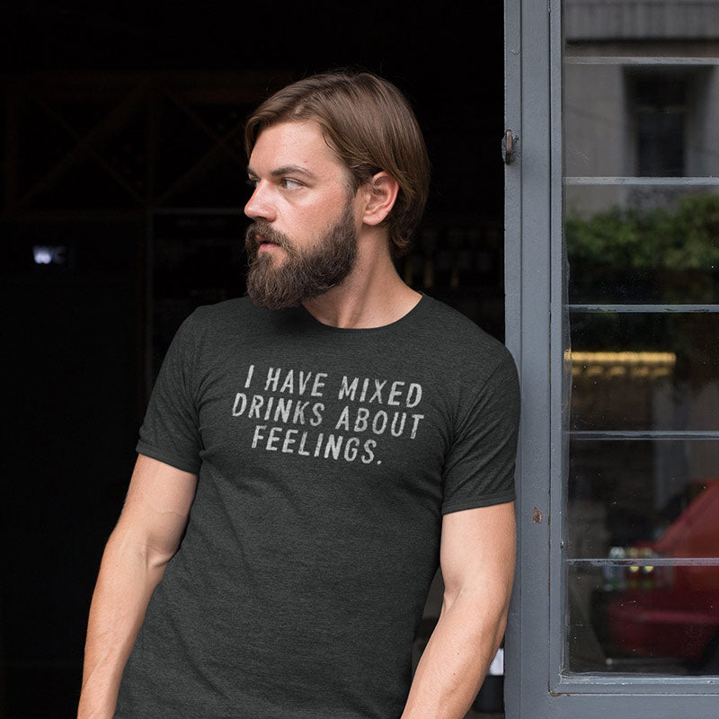 man in bar entryway wearing drinking shirt with the phrase i have mixed drinks about feelings printed in distressed type