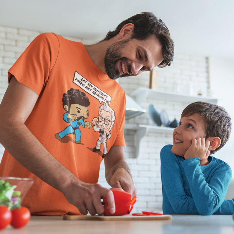 man preparing food with son wearing a chef t shirt with a funny eat my kentucky fried fist general tso cartoon by dodo tees