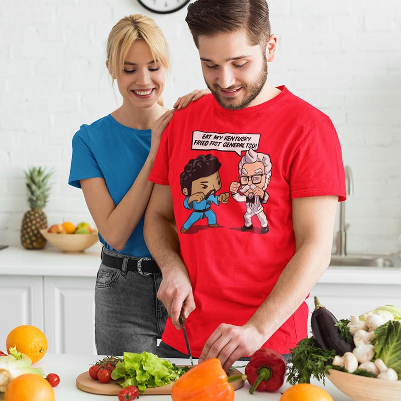 man preparing dinner wearing food t shirt with cartoon that says eat my kentucky fried fist general tso by dodo tees