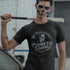 Man holding a bat with a scary painted face wearing a Dodo Tees funny Halloween t shirts featuring Frankenstein's monster and the words Dr. Frankenstein's Cosmetic Surgery