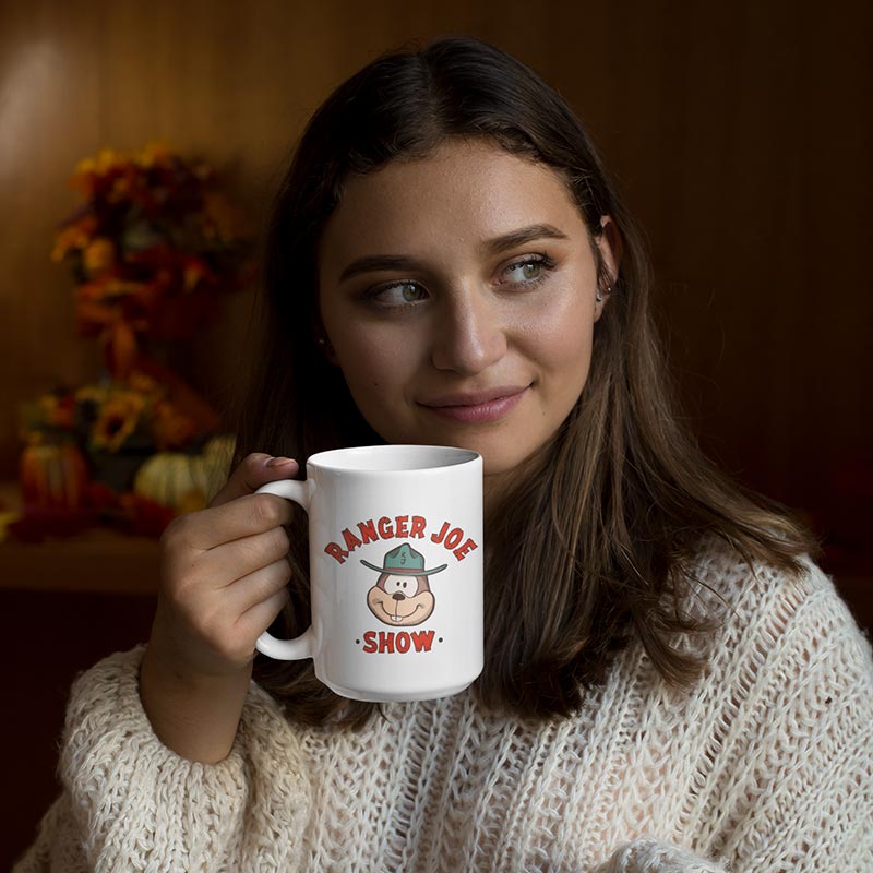 woman in sweater drinking from funny coffee mug with ranger joe show logo