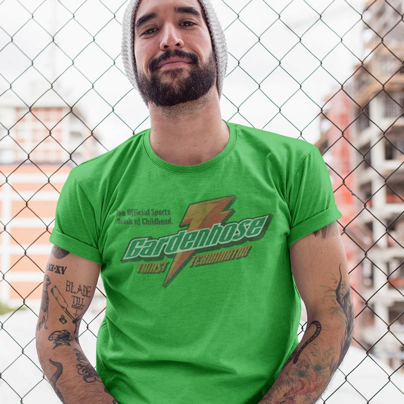 man wearing funny t shirt with gardenhose thirst terminator vintage style print in green standing in front of a fence