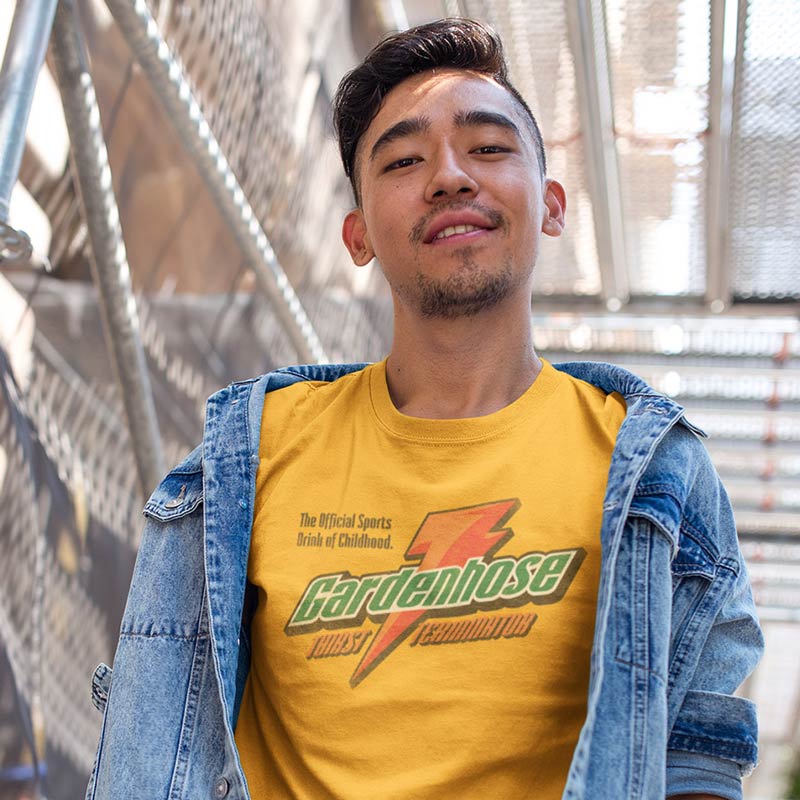 smiling man wearing graphic tee with gardenhose thirst terminator vintage style logo in gold and jean jacket