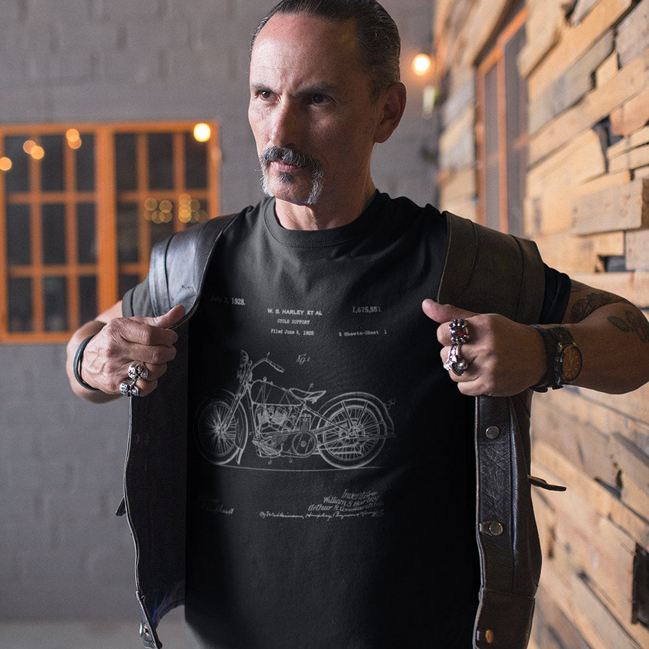 Guy in a leather vest wearing the the Harley shirts for men Dodo Tee with a 1928 Model JD patent. The biker apparel is side-seamed and like a second skin.