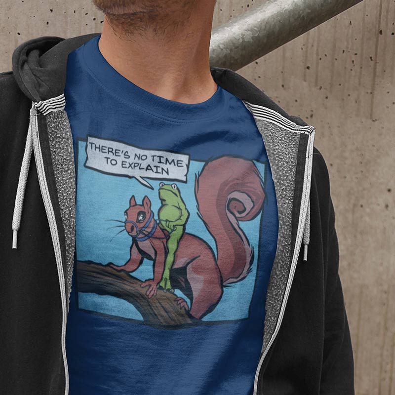 man wearing hoodie and meme t shirt with cartoon of a frog riding a squirrel saying there's no time to explain