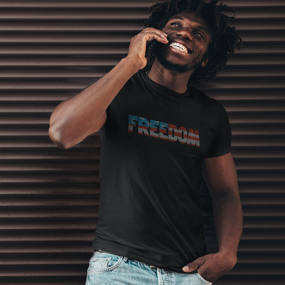 smiling guy wearing a mens fourth of july shirt that reads freedom in a fun font and red white and blue American flag colors. The Patriotic T Shirts For Men are designed and printed in Detroit Michigan. 