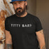 man with a beard wearing a mens funny t shirt that reads titty bar. The Offensive T Shirts feature a handwritten font. 