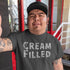 bold tattooed man wearing cream filled offensive t shirts by dodo tees talking selfie