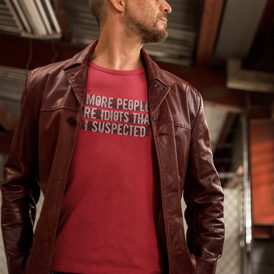 Man in leather coat wearing a red offensive t shirt that reads More people are idiots than I suspected. Funny Shirt design by Dodo Tees.