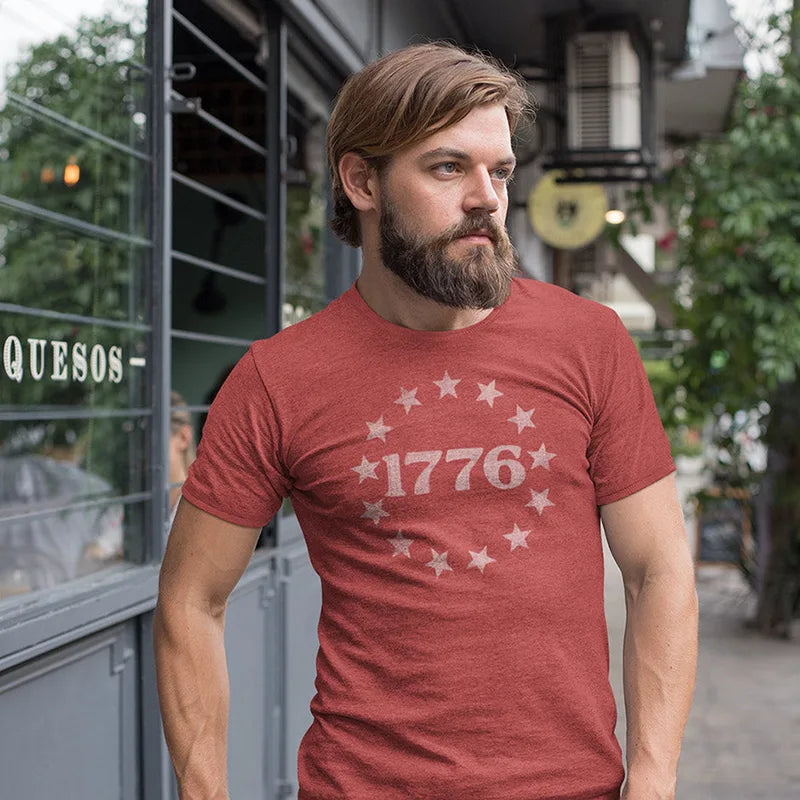 bearded man outside wearing patriotic apparel with 1776 vintage graphic in heather canvas red