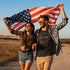 woman and man holding american flag wearing patriotic t shirts with 1776 graphic. The 4th of July Shirt is side-seamed for a modern fit.