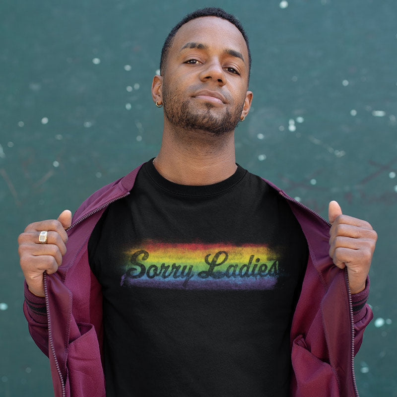 man with open jacket wearing pride shirt with sorry ladies rainbow design