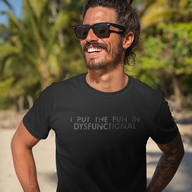 smiling man at beach wearing quirky t shirt with i put the fun in dysfunctional typography