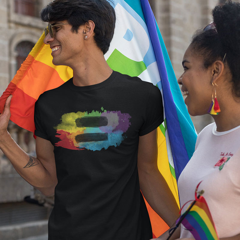 man wearing rainbow shirt with colorful watercolor equal sign graphic at pride festival