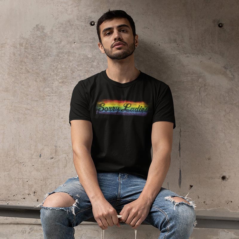 man wearing ripped jeans and rainbow t shirt with sorry ladies design