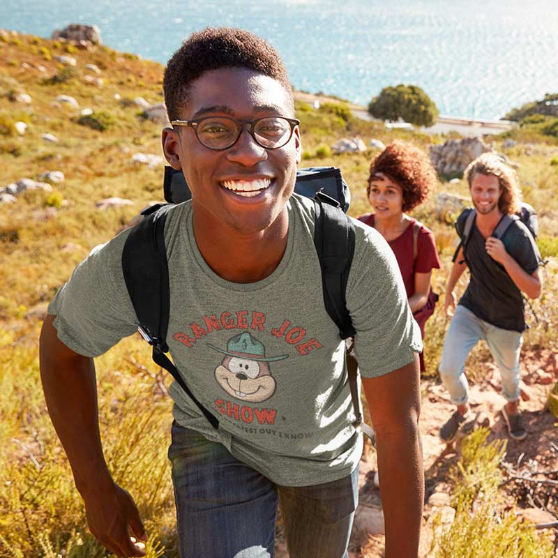 smiling man hiking wearing retro camping tee with ranger joe show graphic