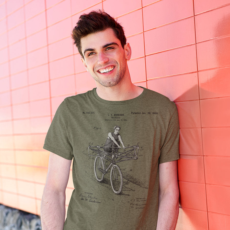 man wearing an olive green funny engineering shirt featuring a 1900 patent for a rowing crew bike.