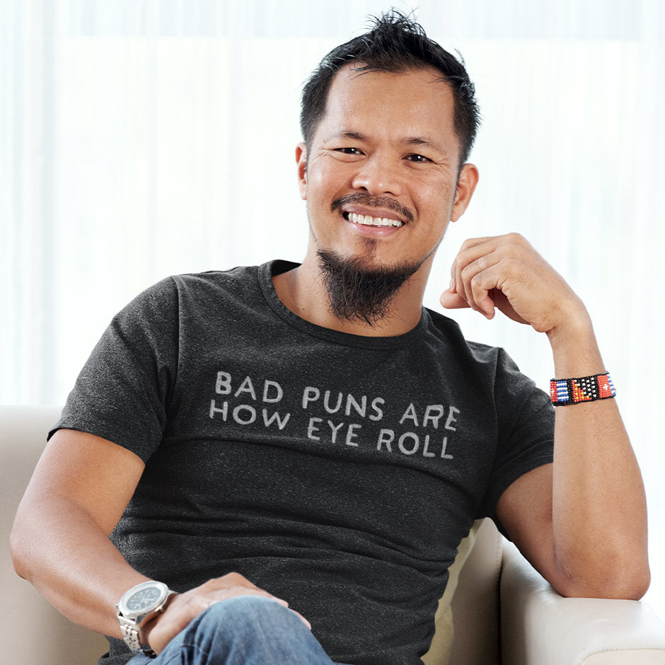 man wearing a sarcastic t shirt from Dodo Tees featuring the words Bad Puns are How Eye Roll. The dad t shirts are side-seamed for a modern fit.