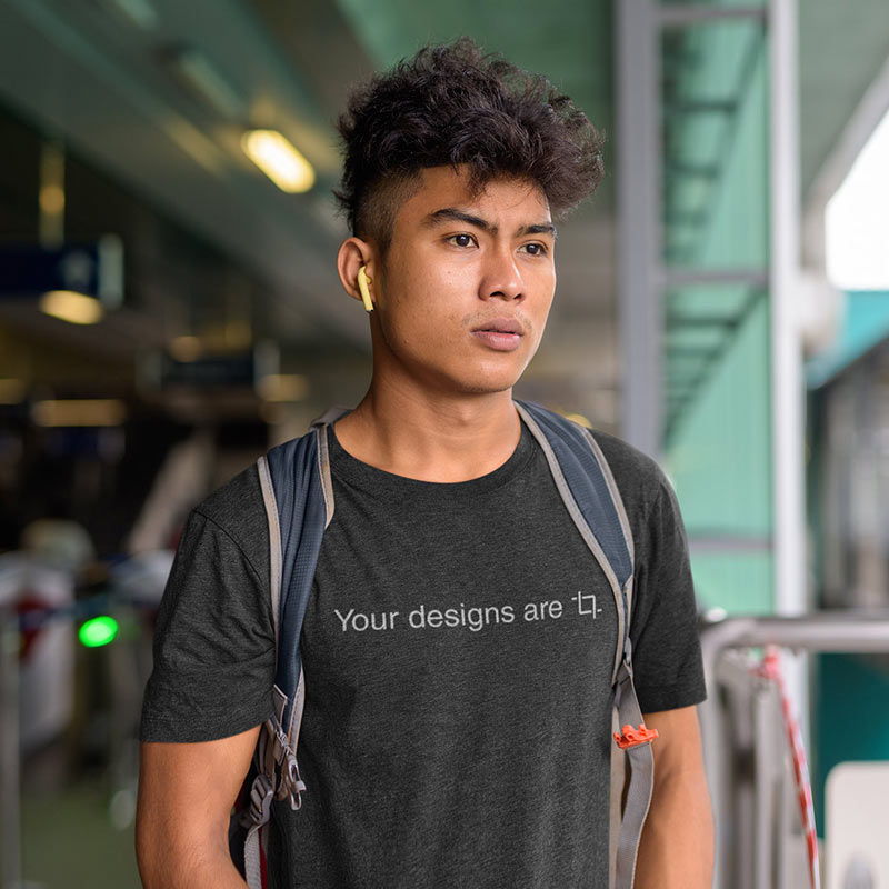 Man with headphones wearing sarcastic t shirt reading Your Designs Are Crop.