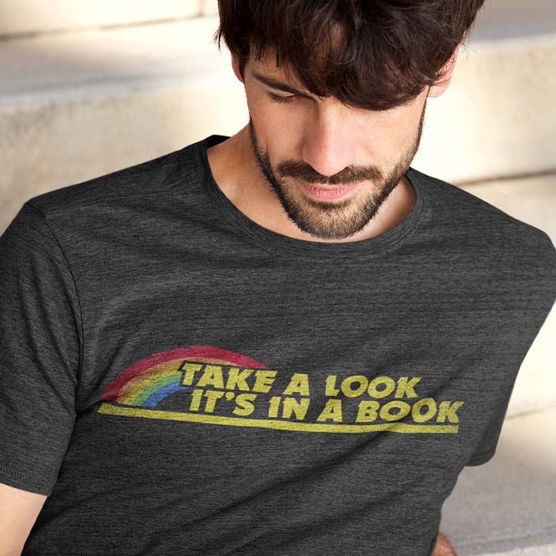 man sitting on stairs wearing t shirt for teachers with take a look its in a book logo