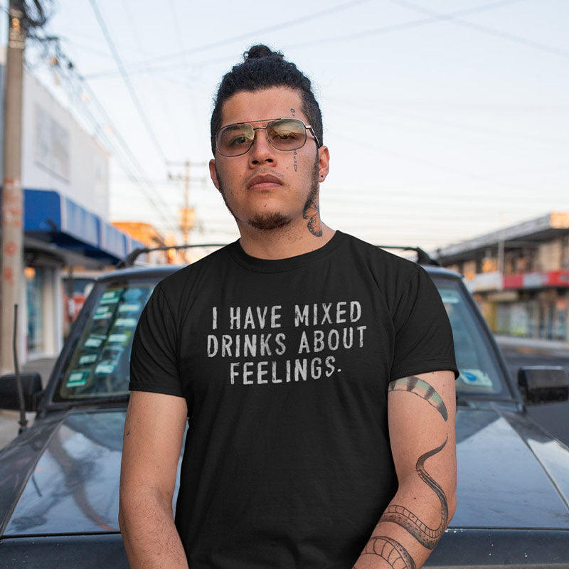 tattooed man wearing whiskey shirt with the words "i have mixed drinks about feelings" printed on the front