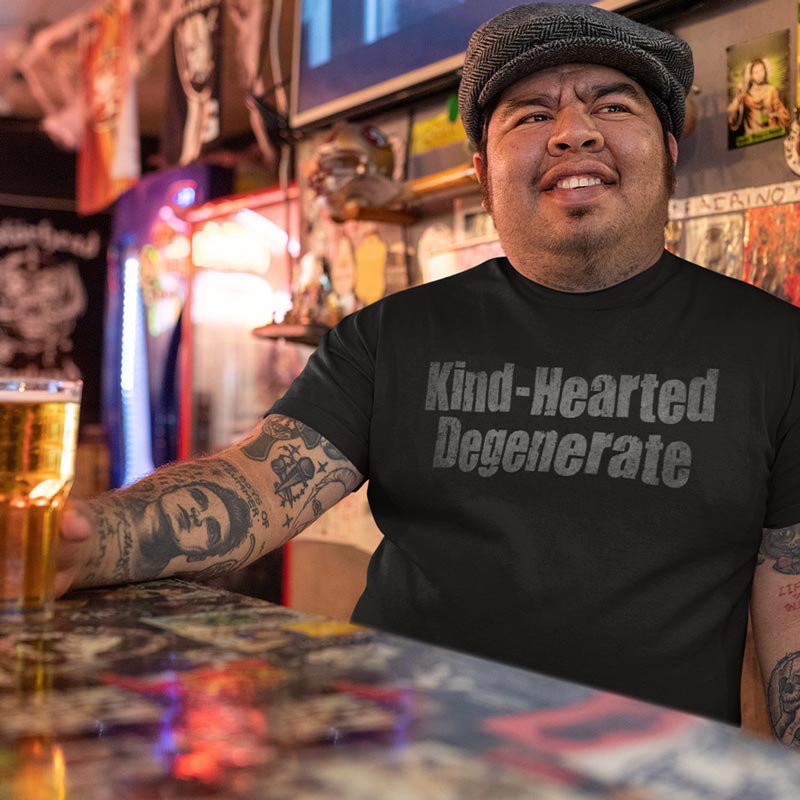 A lifestyle shot of the 'Kind Hearted Degenerate' whiskey shirts, worn casually.