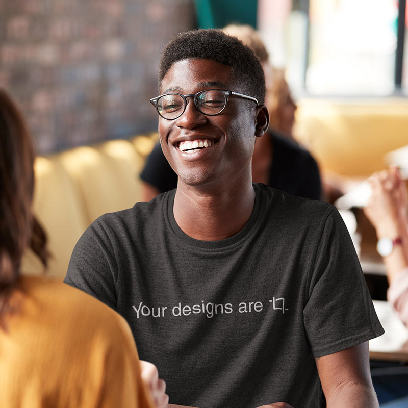 man smiling in coffee shop wearing your designs are crop typography t shirt