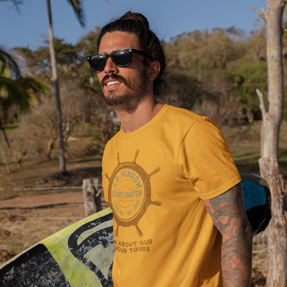 surfer wearing boating t shirt with ss minnow logo. The surfing t shirts have a vintage sun soaked vibe.