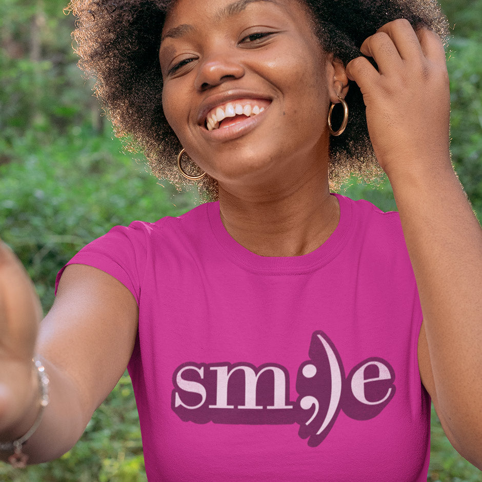 happy woman taking selfie wearing smile t shirt in pink